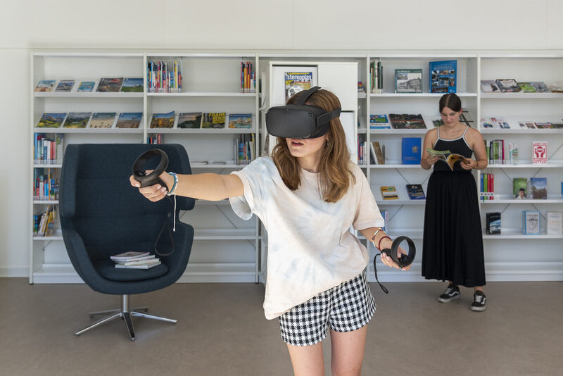 Eine Frau probiert eine VR-Brille aus.