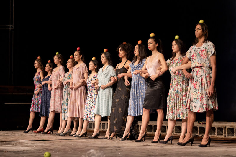 Das Ensemble in einer Szene aus Palermo Palermo: Tänzerinnen schreiten in einer Reihe und tragen dabei einen Apfel auf dem Kopf