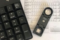 Tastatur und Lupe auf einer Bilanz