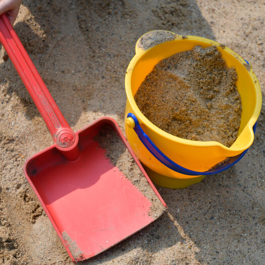 Einer und kleine Schaufel in einem Sandkasten