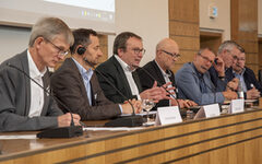 Das Podium der Tagung mit Minister Krischer (Mitte) und Oberbürgermeister Schneidewind (Dritter v.r.)
