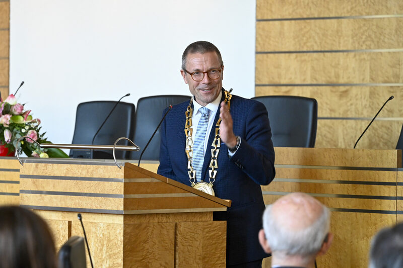 Oberbürgermeister Uwe Schneidewind am Rednerpult mit Geste zu Eberhard Hasenclever in der ersten Reihe sitzend