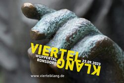 Das Logo des diesjährigen Viertelklang zeigt die Hand einer Bronze-Figur, die auf dem Bandwirkerplatz in Ronsdorf steht