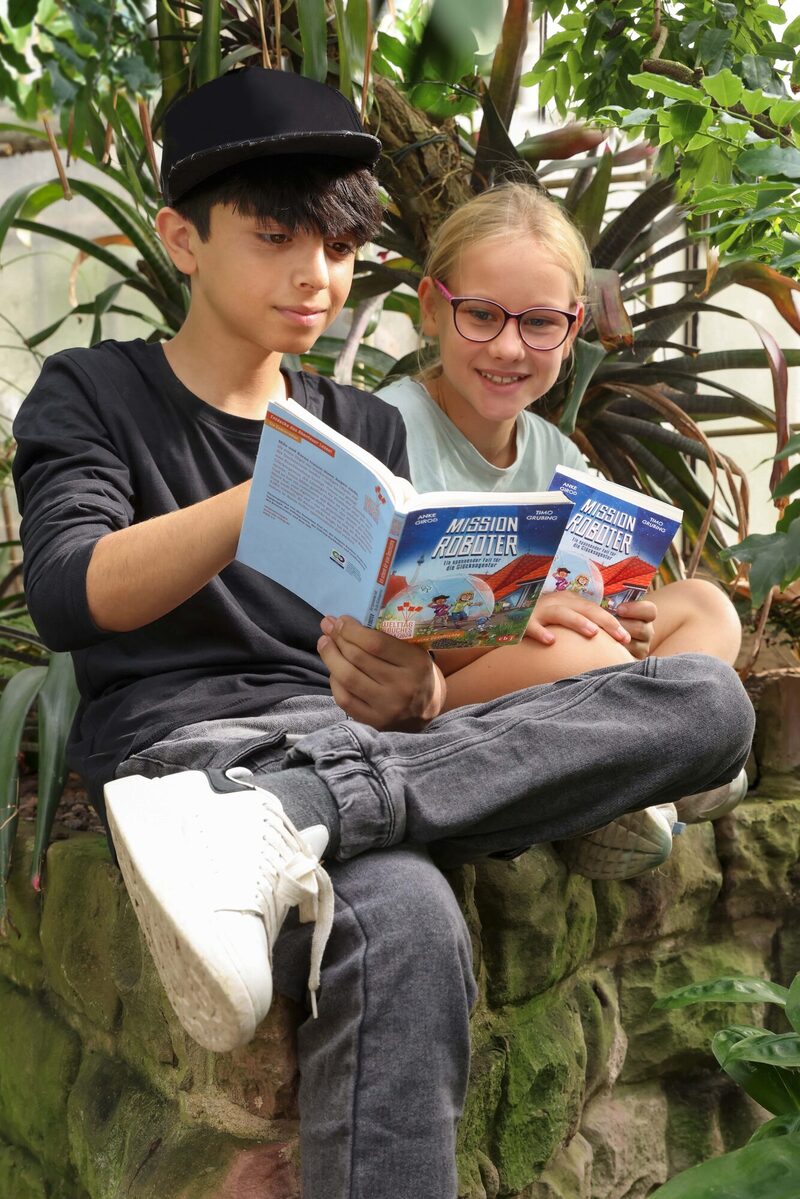 Kinder lesen in dem Buch "Mission Roboter"
