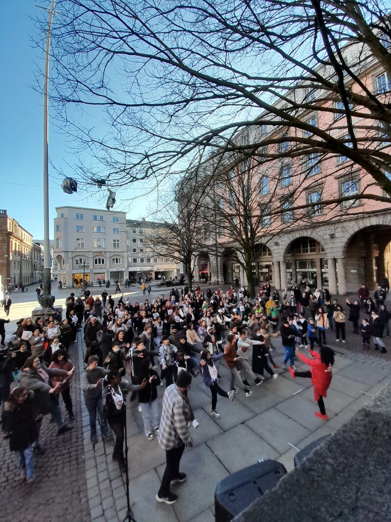 Tanzaktion "One Billion Rising" 2023: Zahlrieche Menschen tanzen vor dem Rathaus.