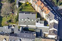 Luftbildaufnahme: Blick von oben auf die Turnhalle, weitere Dächer und Gärten