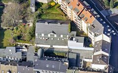 Luftbildaufnahme: Blick von oben auf die Turnhalle, weitere Dächer und Gärten