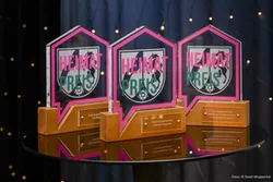 Das Bild zeigt die drei Heimatpreise, ein stilisiertes Häuschen mit dem Wappen von NRW