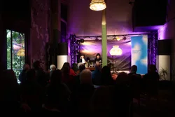 Das Bild zeigt eine Lesung mit Wohnzimmerlampe während der Literatur Biennale im vergangenen Jahr