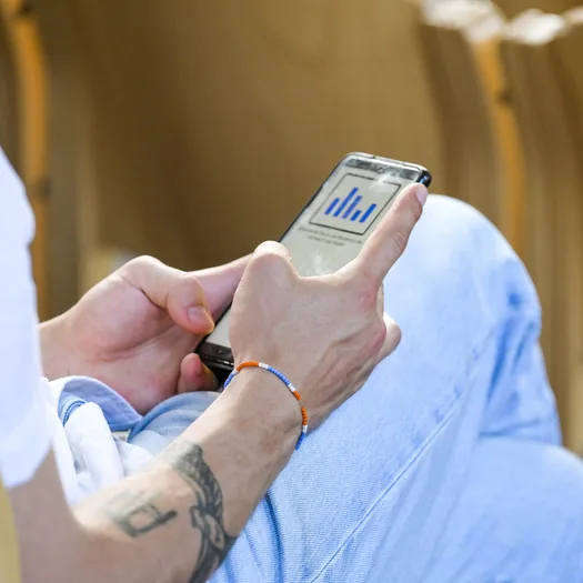 Symbolbild: Eine Person hält ein Smartphone in der Hand.