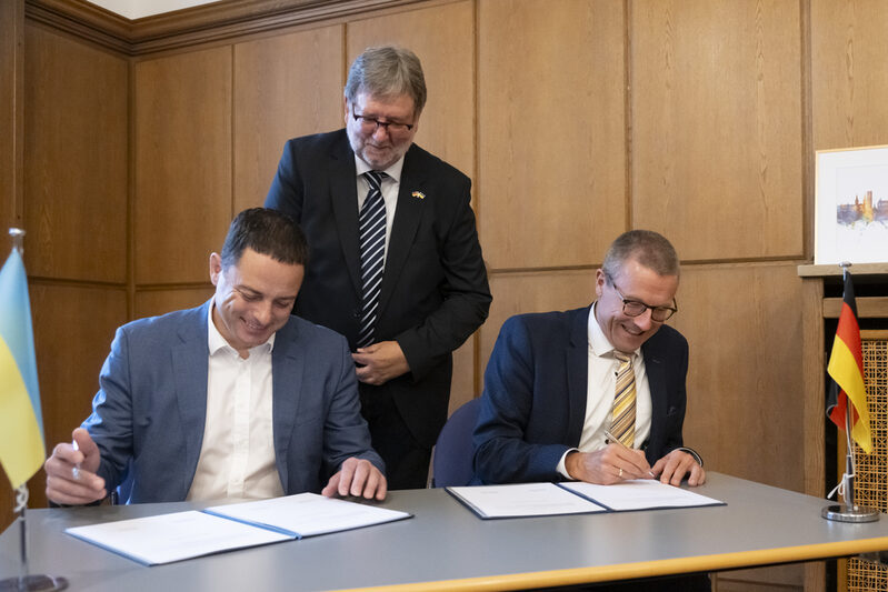 Oberbürgermeister Uwe Schneidewind (rechts) und sein Amtskollege aus Kamjanske unterzeichnen den Kooperationsvertrag.