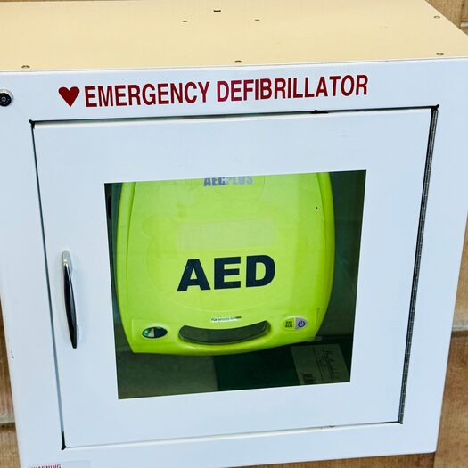 Ein Defibrillator hängt an einer Wand