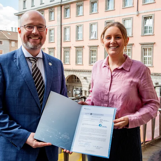 OB Miriam Scherff nimmt das Zertifikat von Fabian Hodouschek, Leiter der Zertifizierungsstelle des BSI, entgegen.