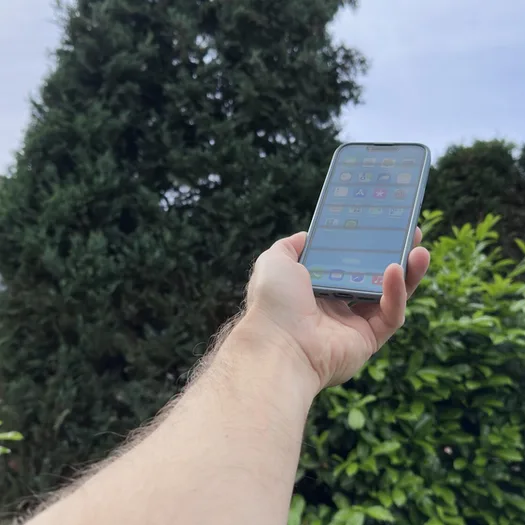 Hand hält Handy in die Luft