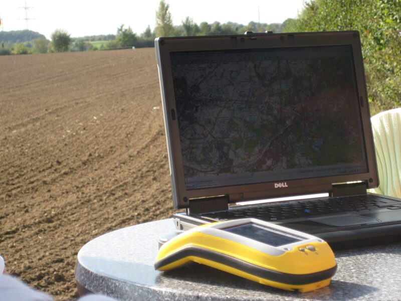 GPS-Empfänger und Laptop auf einem Tisch am Feldesrand