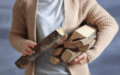 Woman holding pile of firewood, close up view