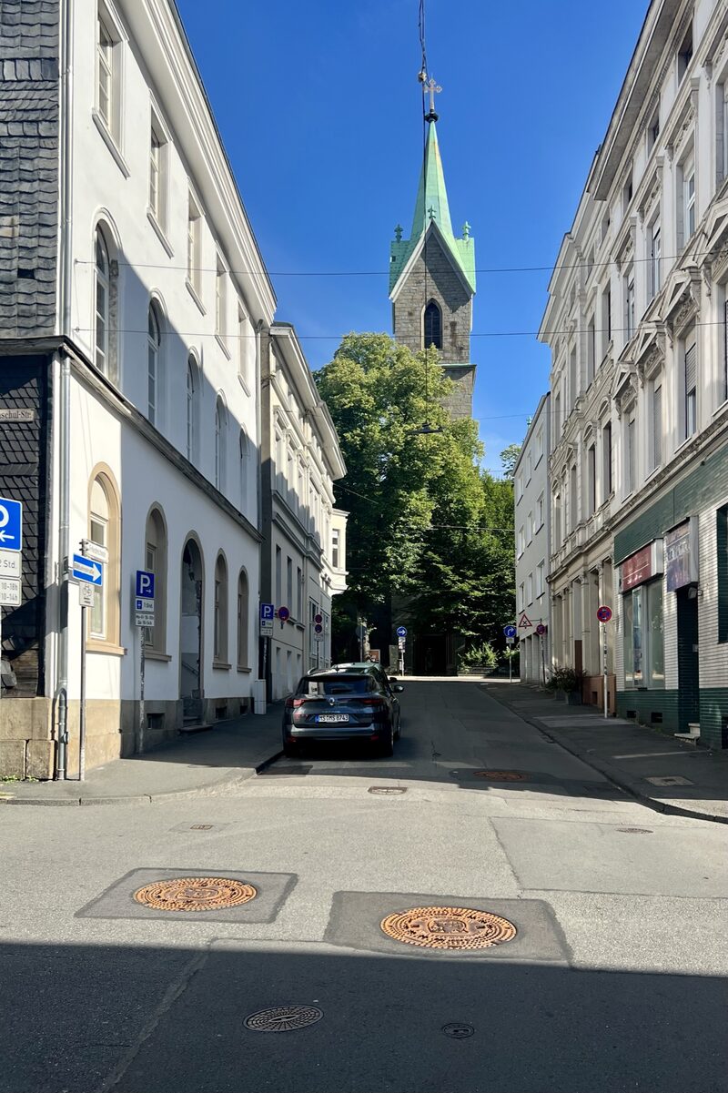 Straße mit parkenden Autos und Kirche