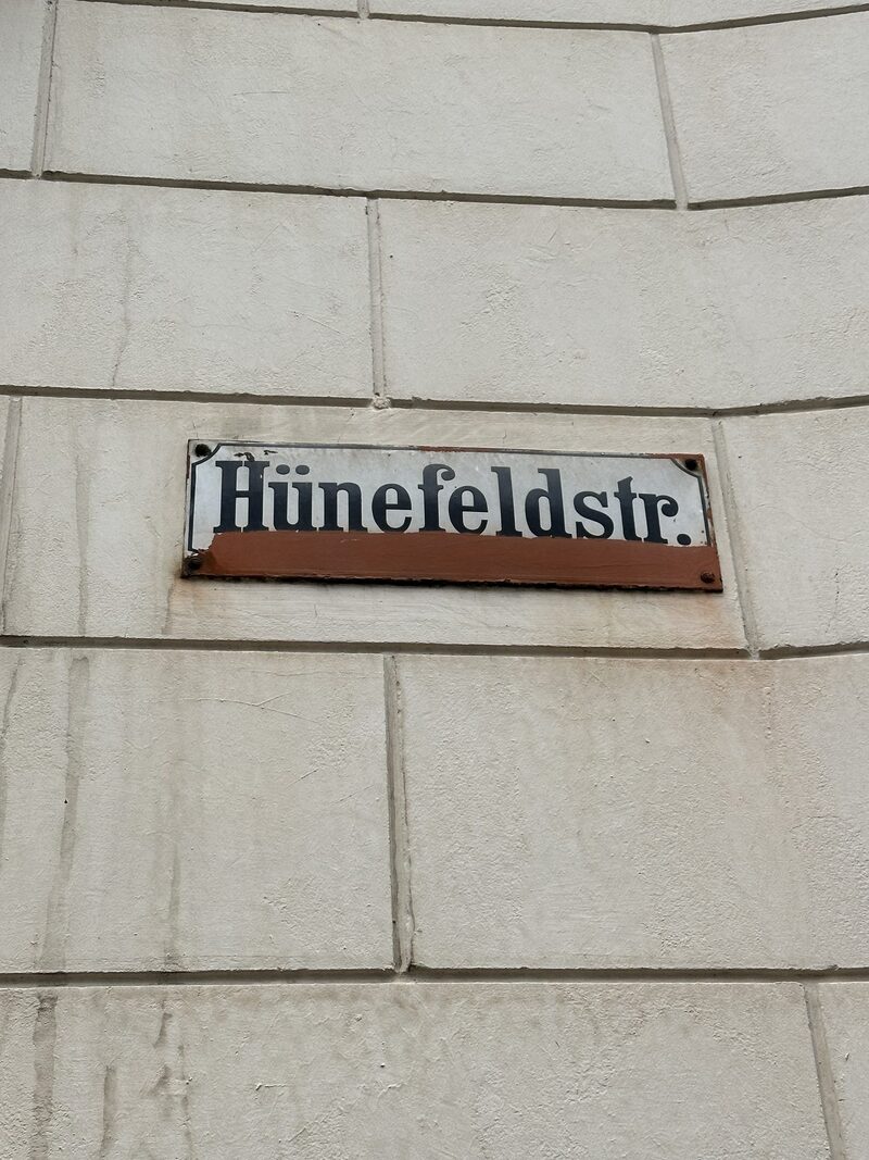 Schild mit Straßennamen "Hühnefeldstraße" an Hauswand