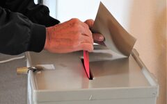 Ein Wahlbrief wird in eine Wahlurne geworfen
